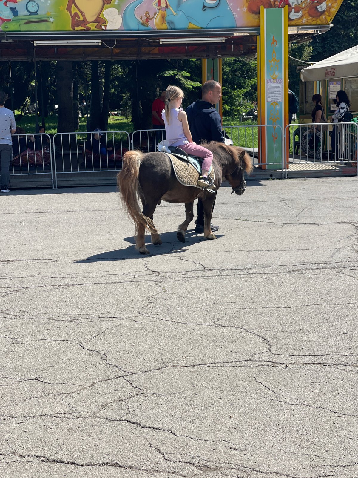 Family enjoys morning amusement park visit with poodle in Sofia