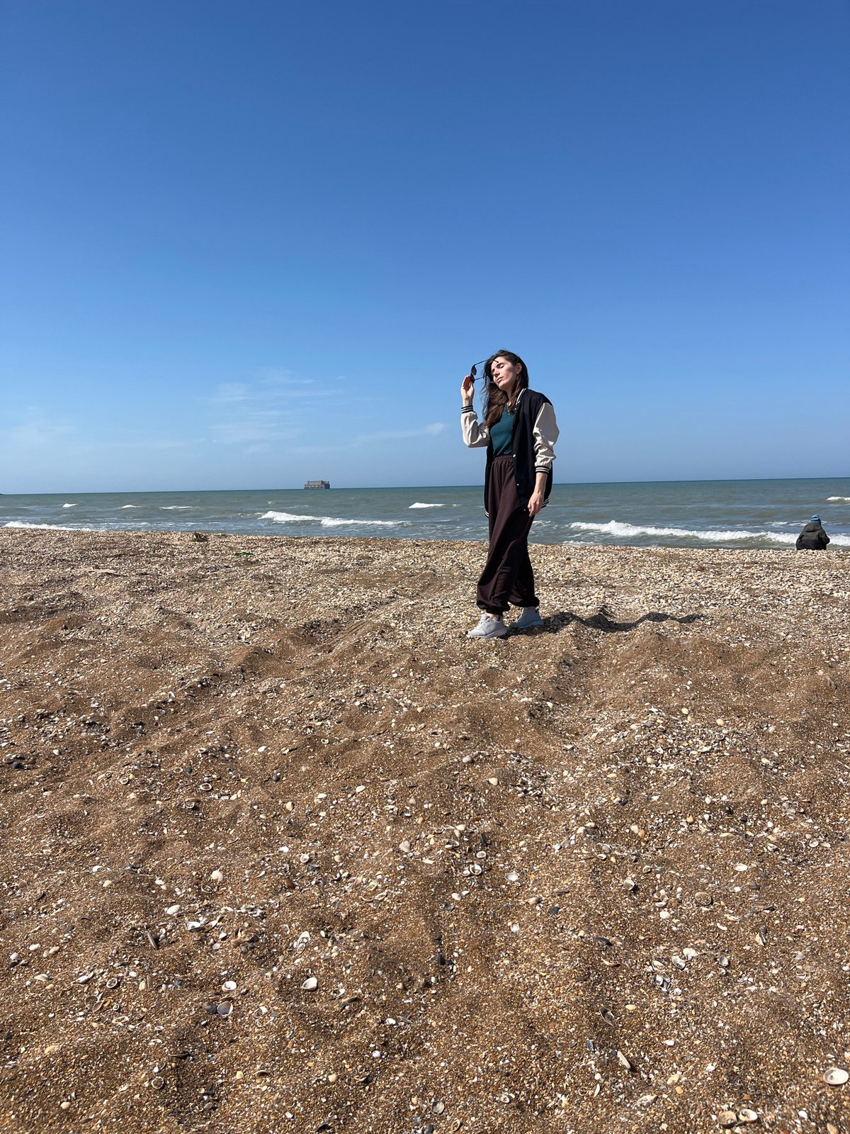 Woman stands on beach in Kaspiysk, Russia