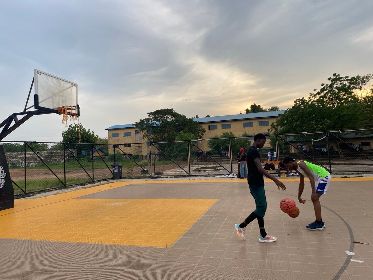 Young men play pickup basketball in Lagos