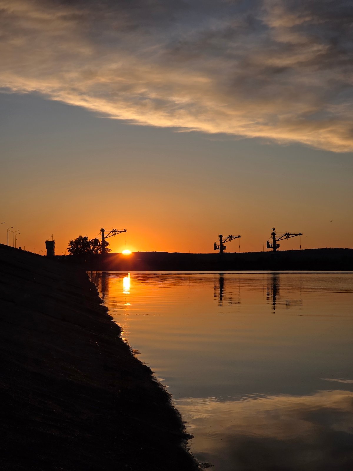 Woman documents sunset evening along Kama River in Chaikovsky