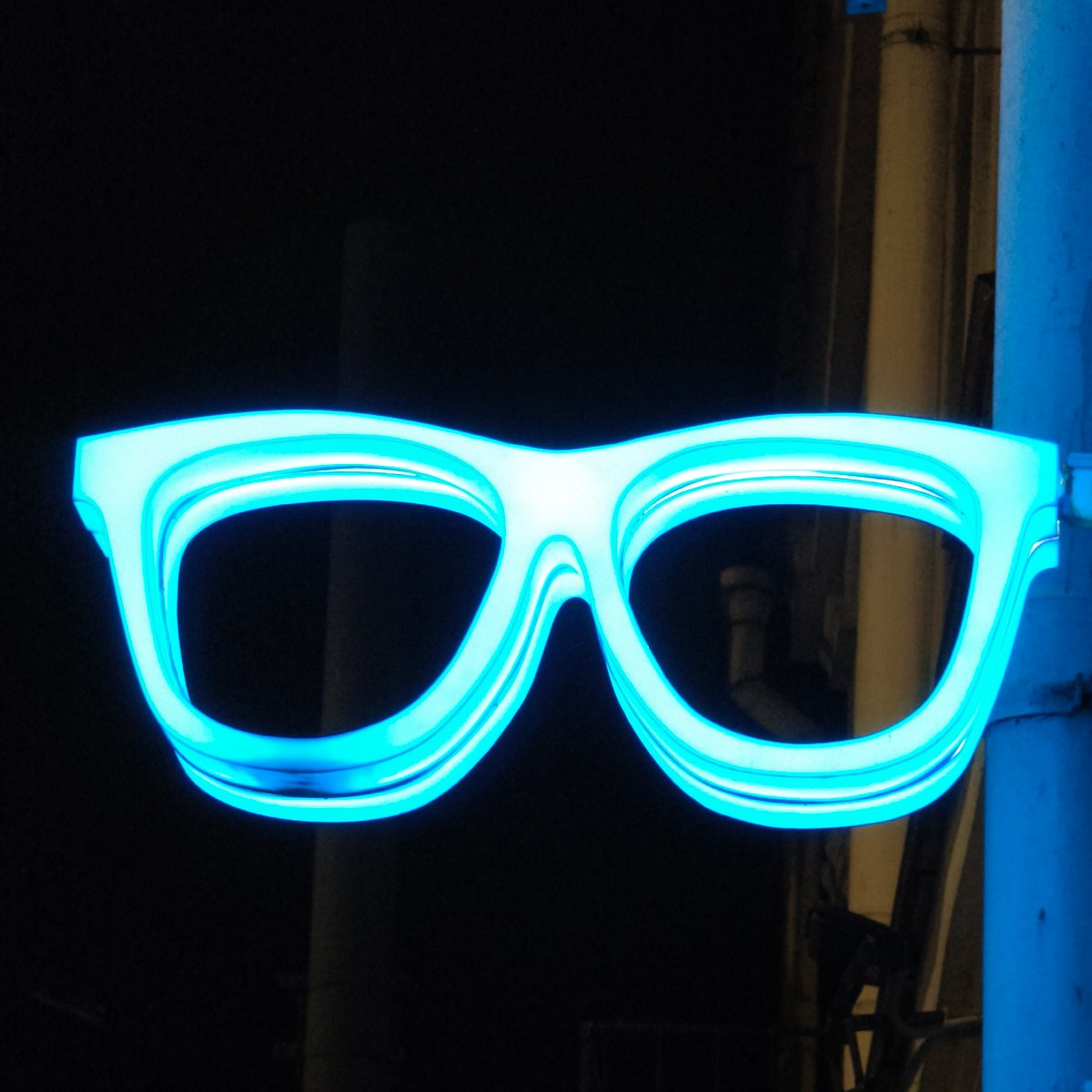Neon eyeglasses sign glows in evening Hrodna street