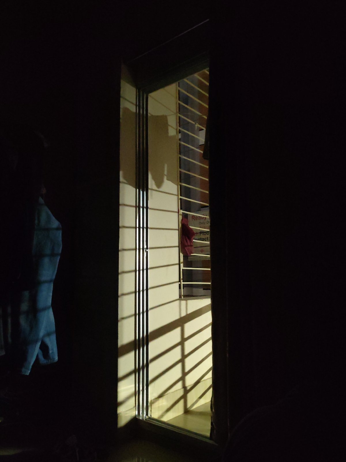Light streams through window in dimly lit Dhaka interior
