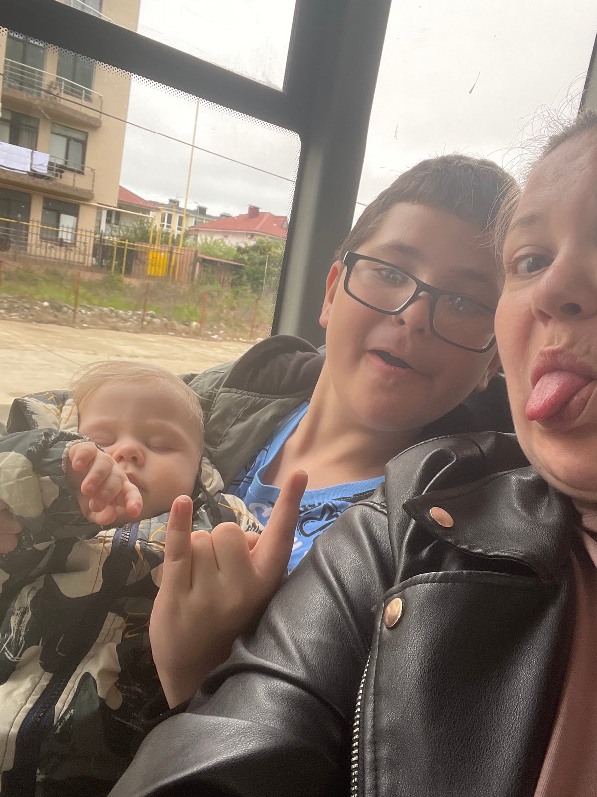 Adult holds sleeping child during vehicle journey in Russia