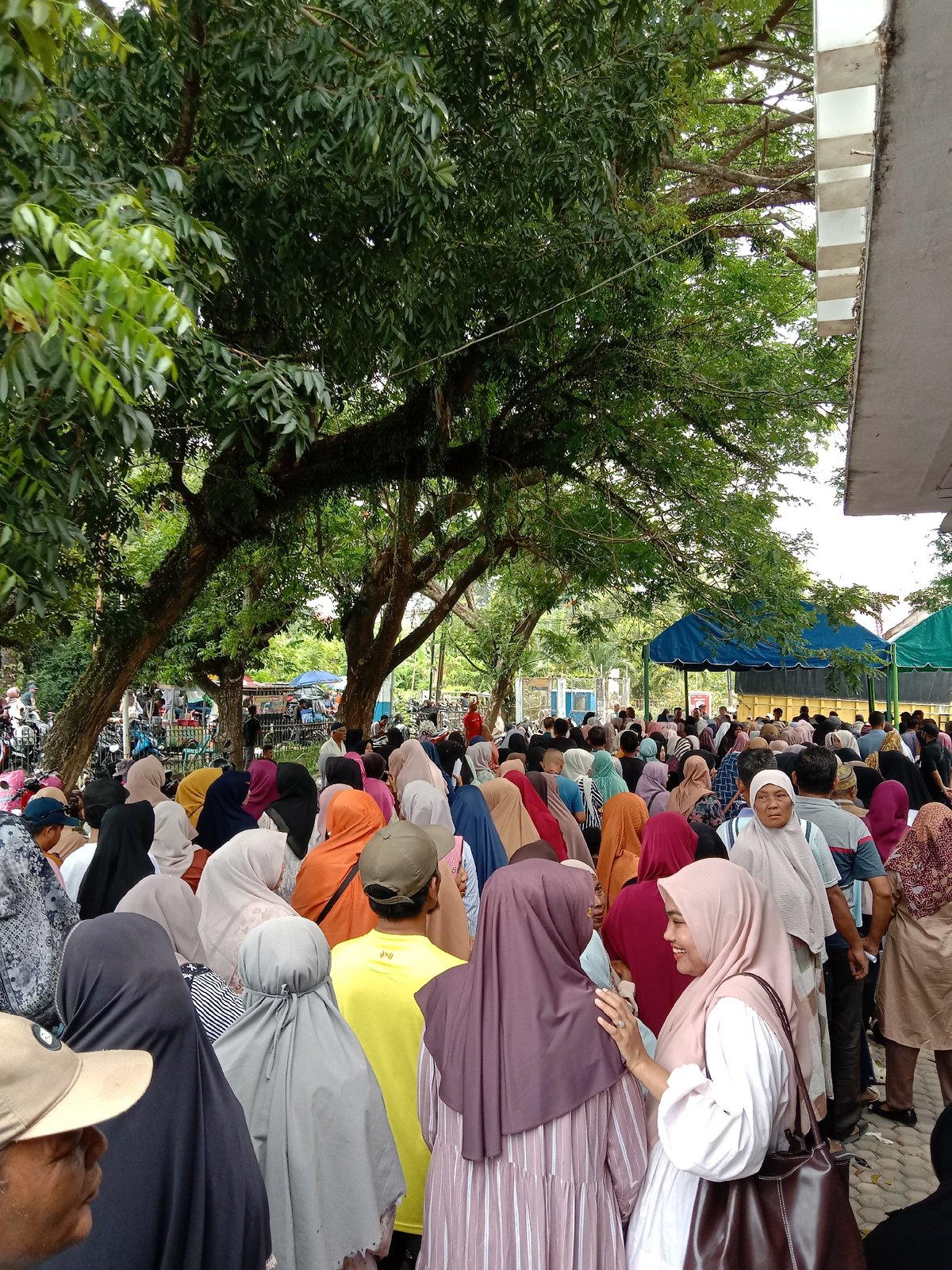 Women queue under tents in Lhokseumawe morning gathering