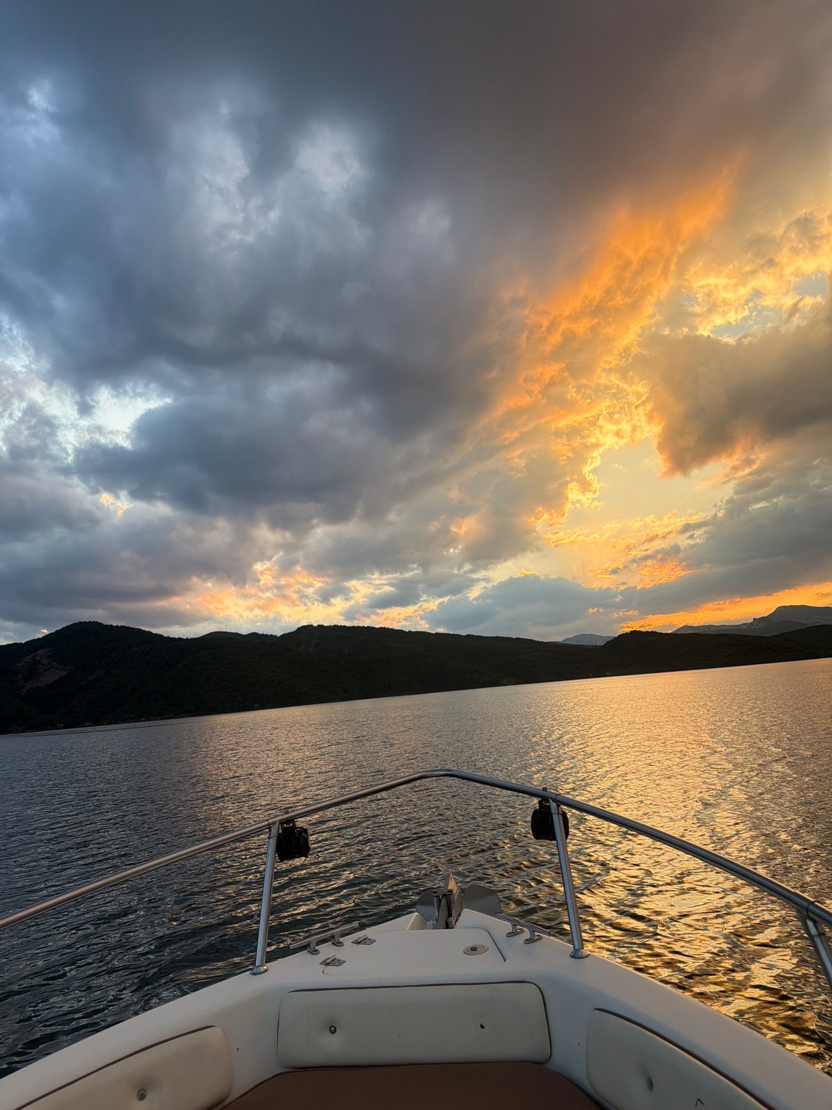 Boat on Koprinka Reservoir under a dramatic summer sunset