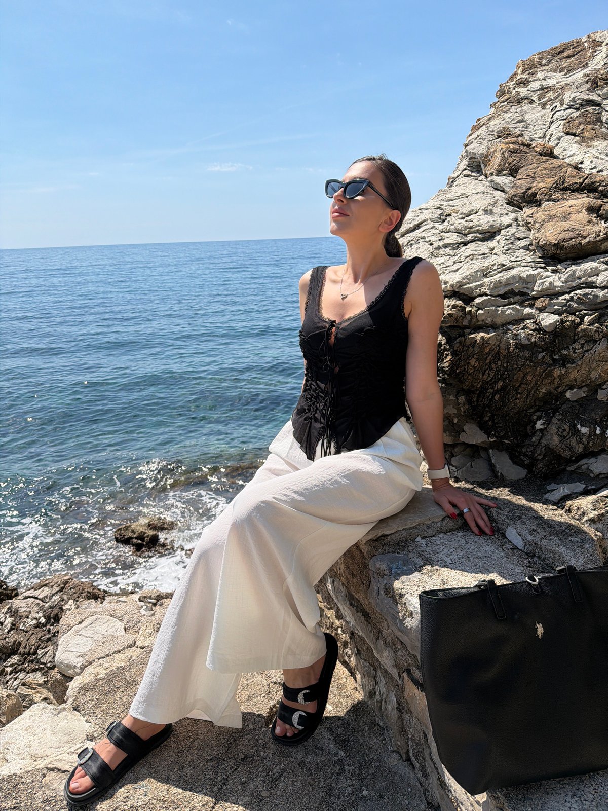 Woman poses for photos on sunny Budva coastline