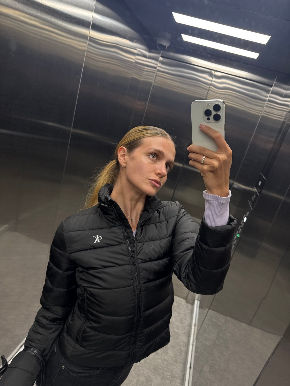 Woman Takes Elevator Selfie with iPhone in CK Jacket