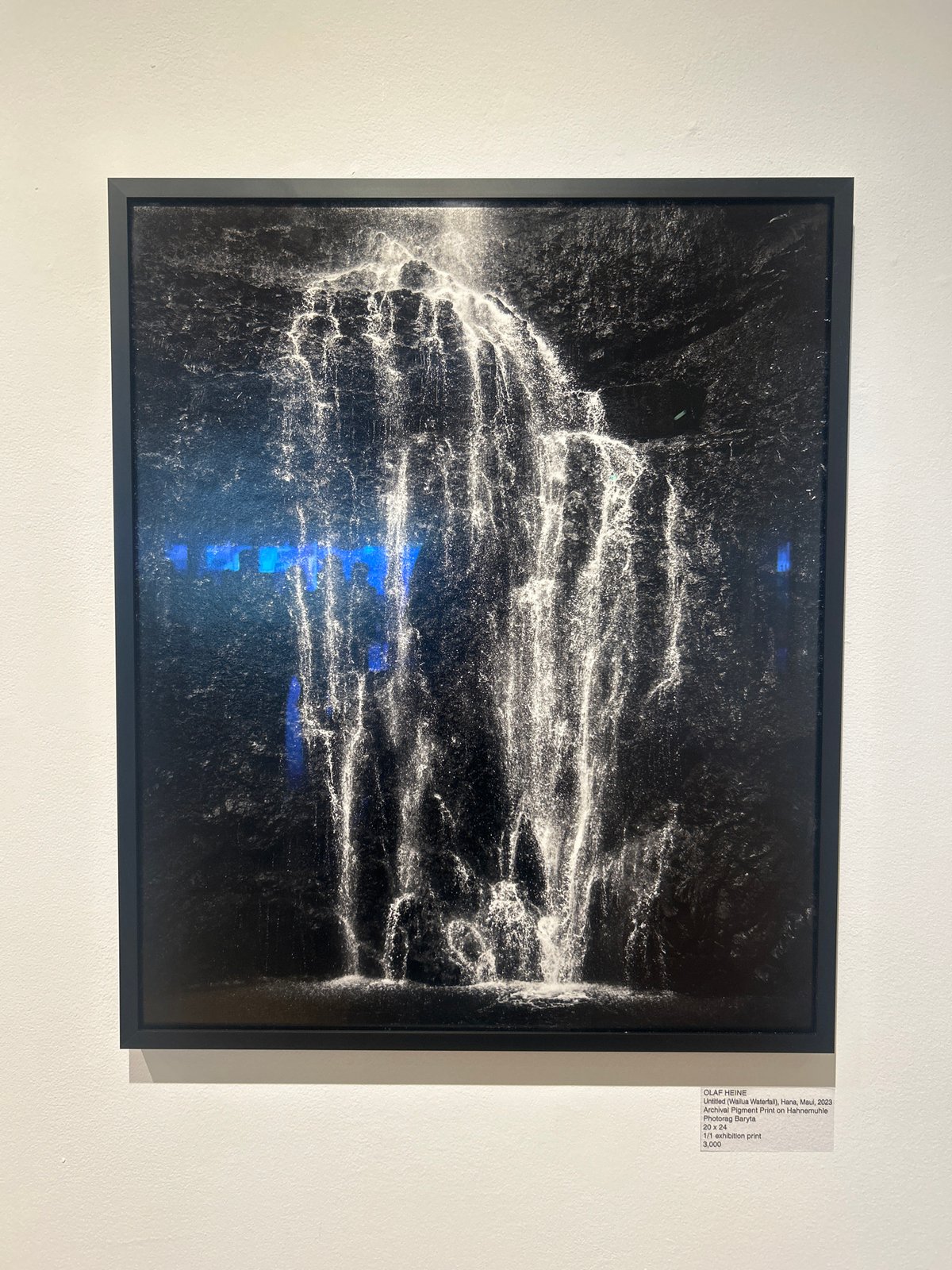 Late-night art viewing of water cascade photograph in West Hollywood