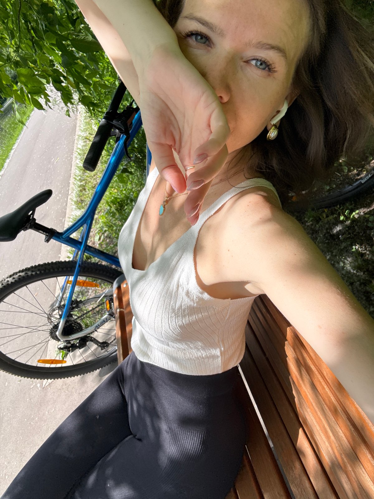 Woman cycles, rests in Moscow park during sunny morning