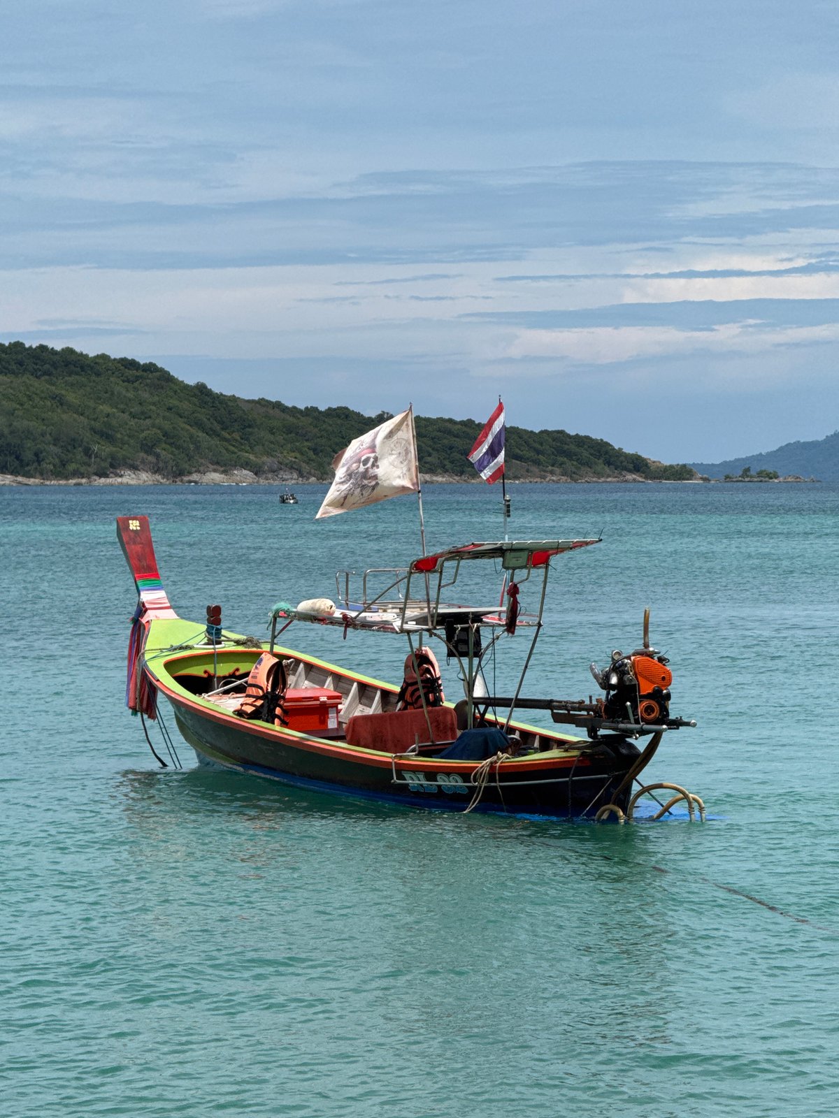 Longtail boats at rest in calm waters off Rawai