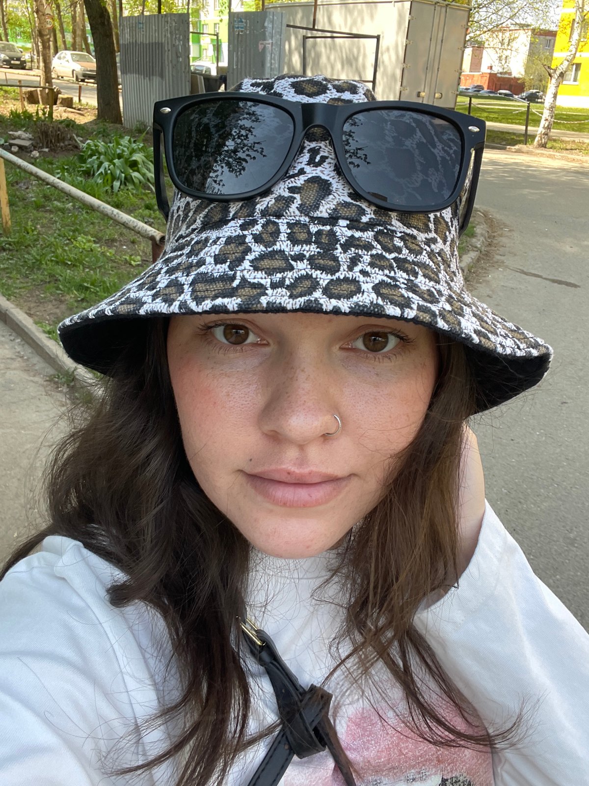 Woman photographs herself in Izhevsk park, apartment building