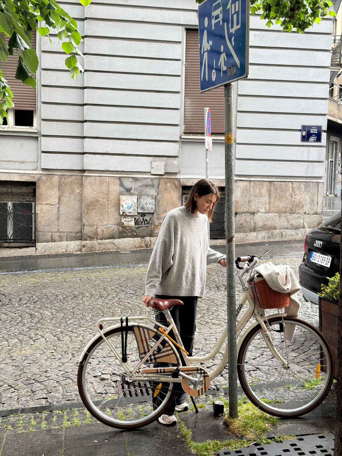 Woman with bicycle spotted on Belgrade cobblestone street
