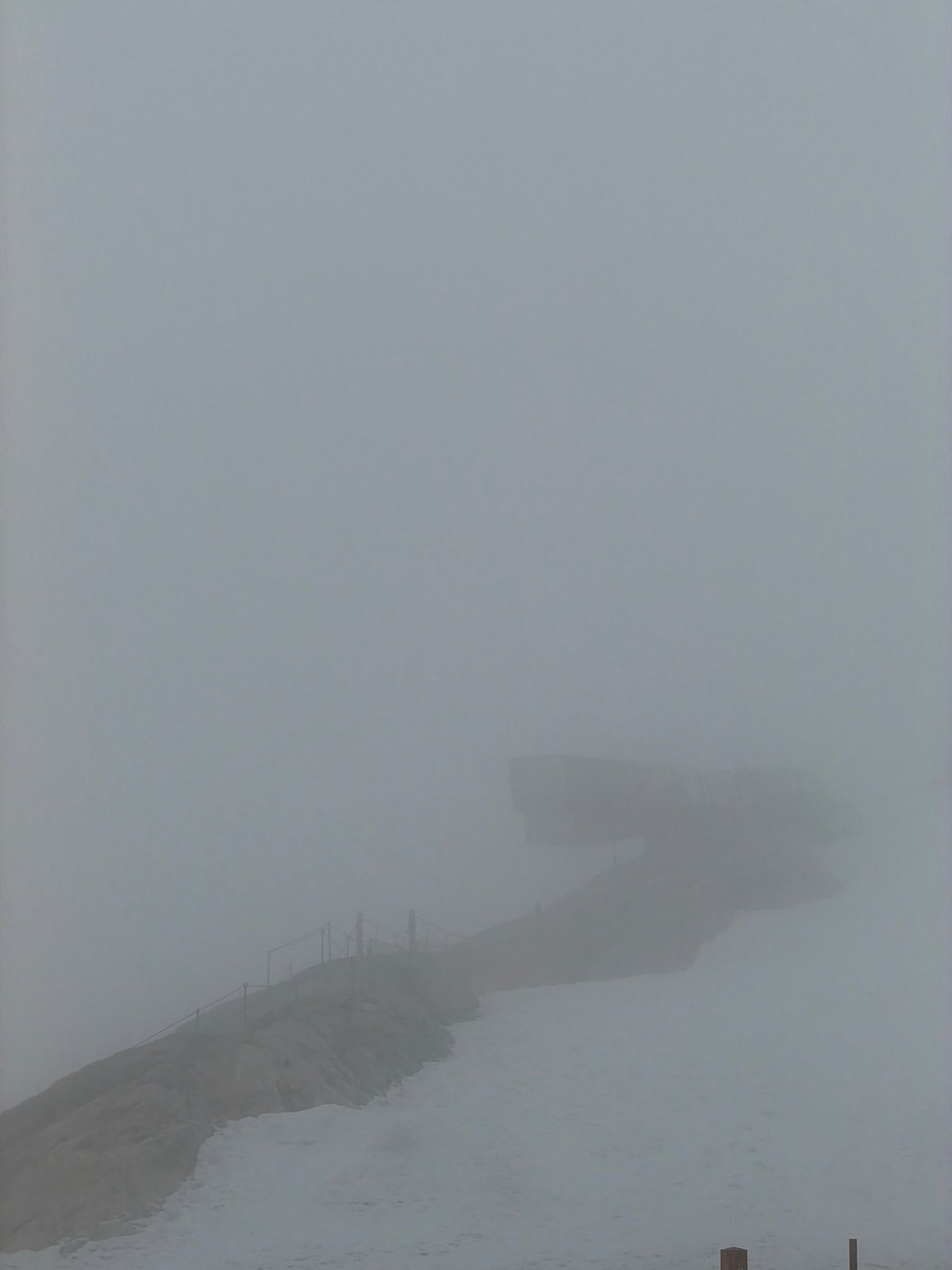 Dense fog shrouds Garmisch-Partenkirchen mountain observation platform, dining areas