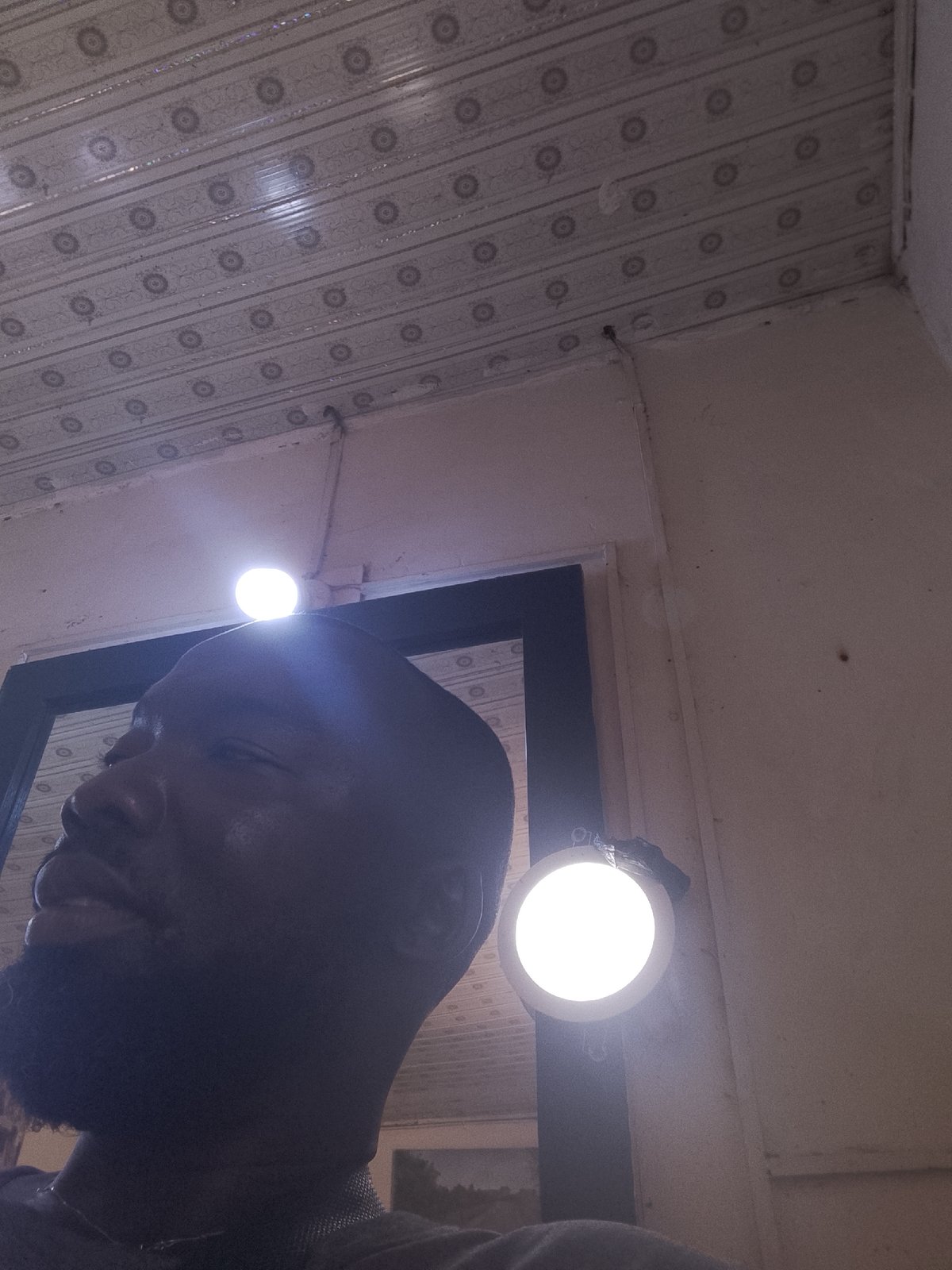 Person photographed between doorframe lights at unknown location