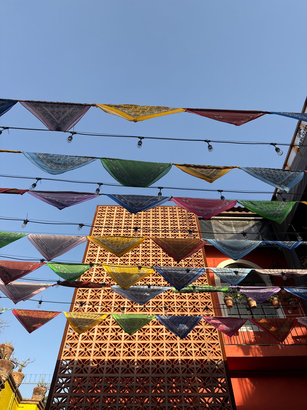Colorful triangular flags captured hanging from lights in Puebla