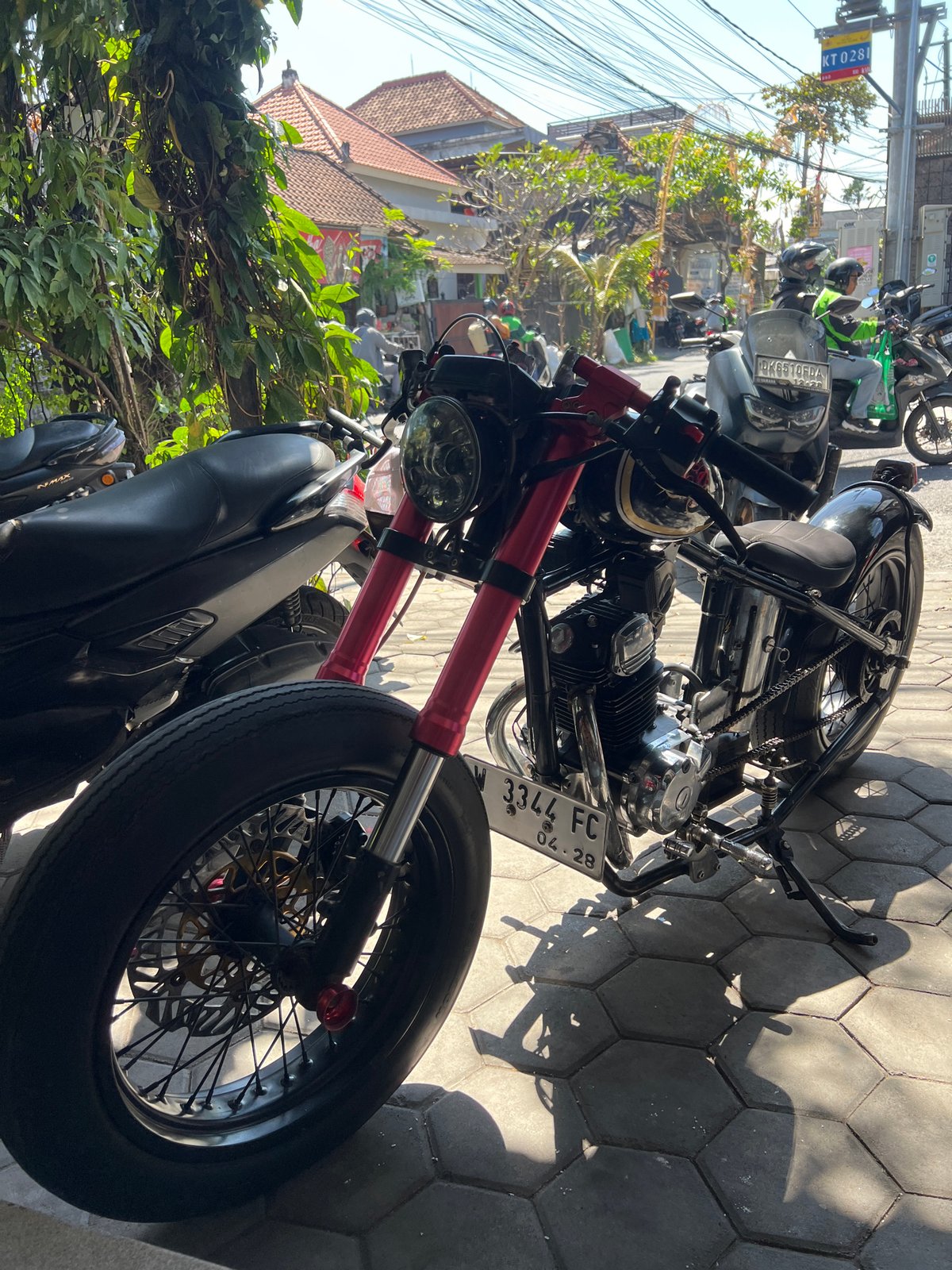 Custom motorcycle parked on tiled sidewalk in North Kuta