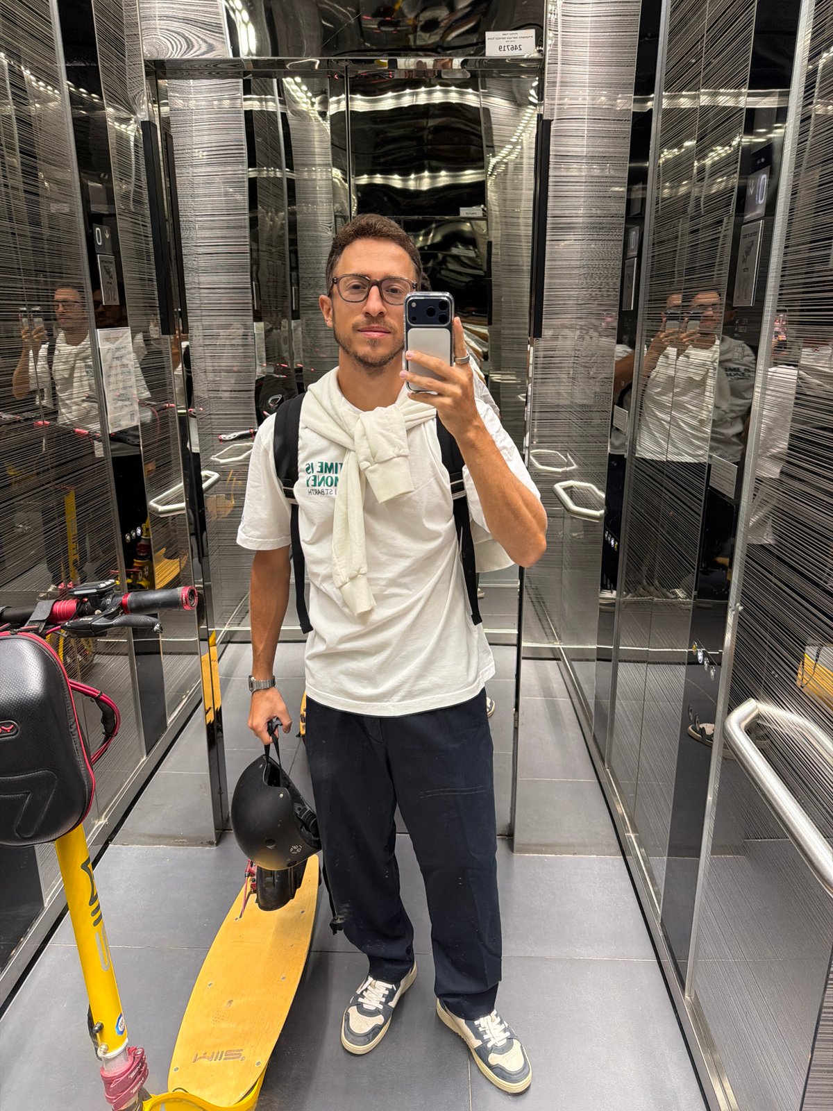 Man takes elevator selfie with yellow scooter and helmet