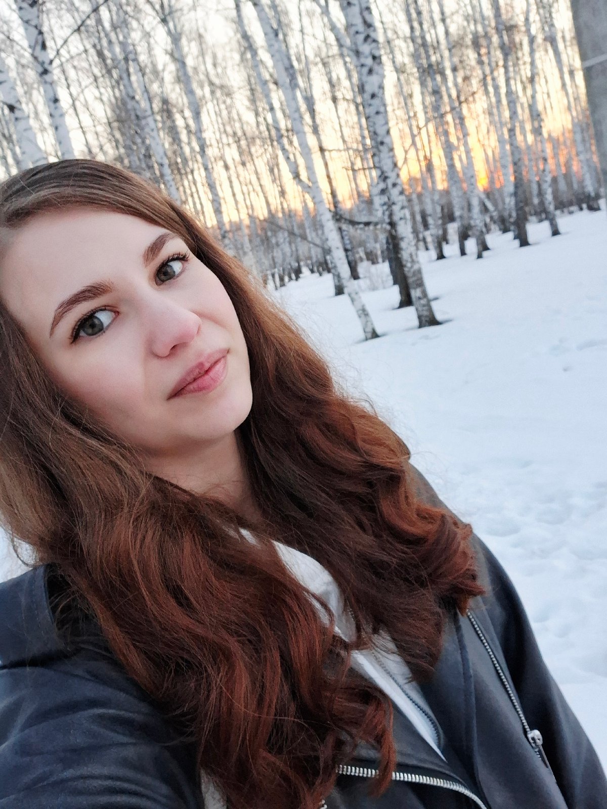 Young women pose for photos along snowy Kama River