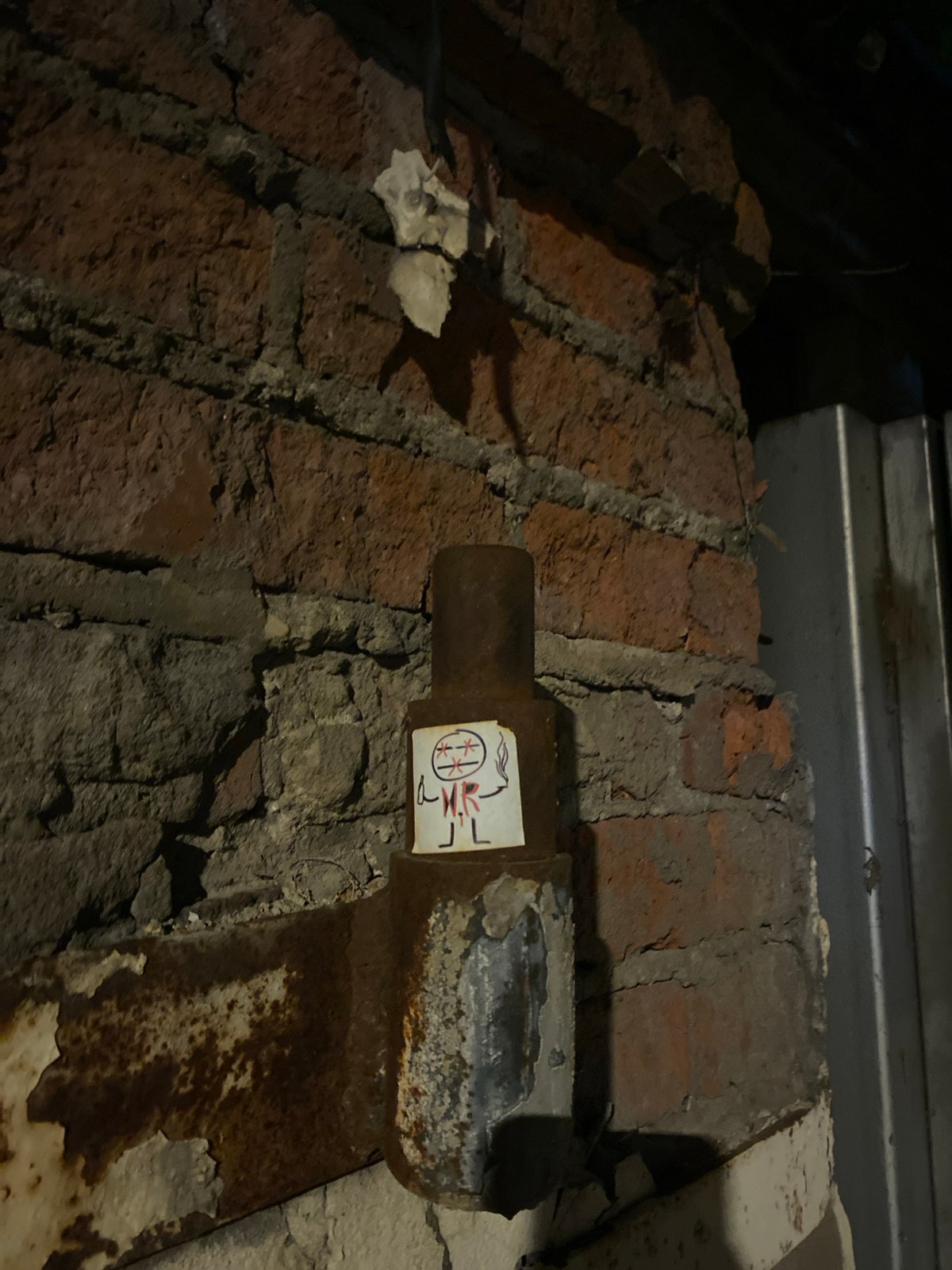 Moscow building shows crumbling wall, pipe with sticker