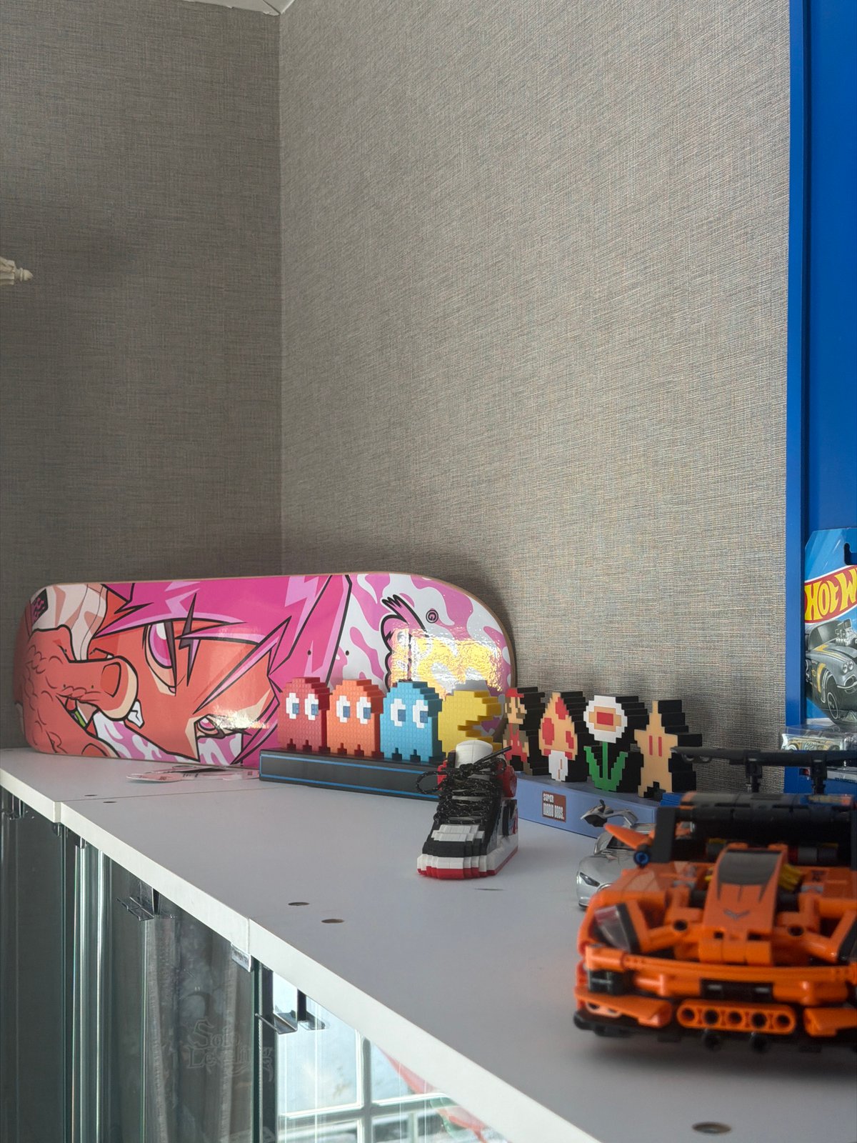 Pink anime skateboard displayed on white shelf in Chalong