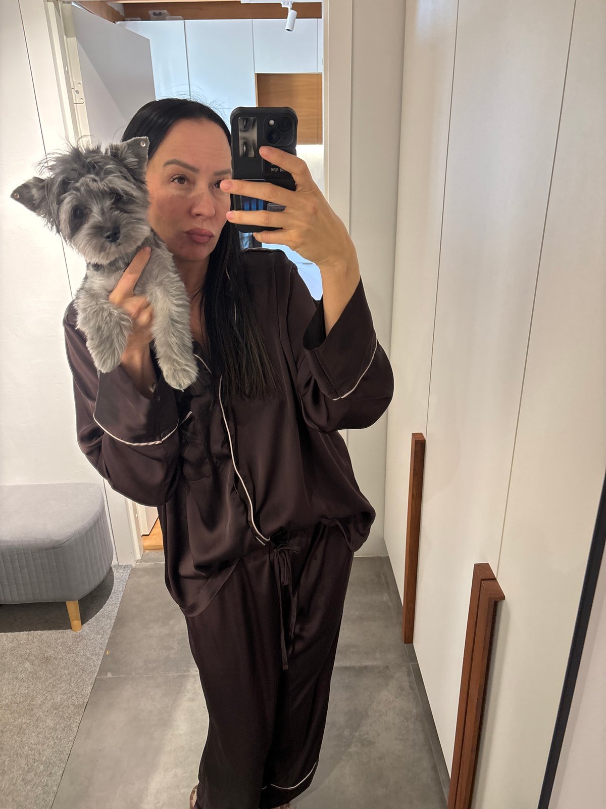 Person photographs pet dog at home in Chaikovsky