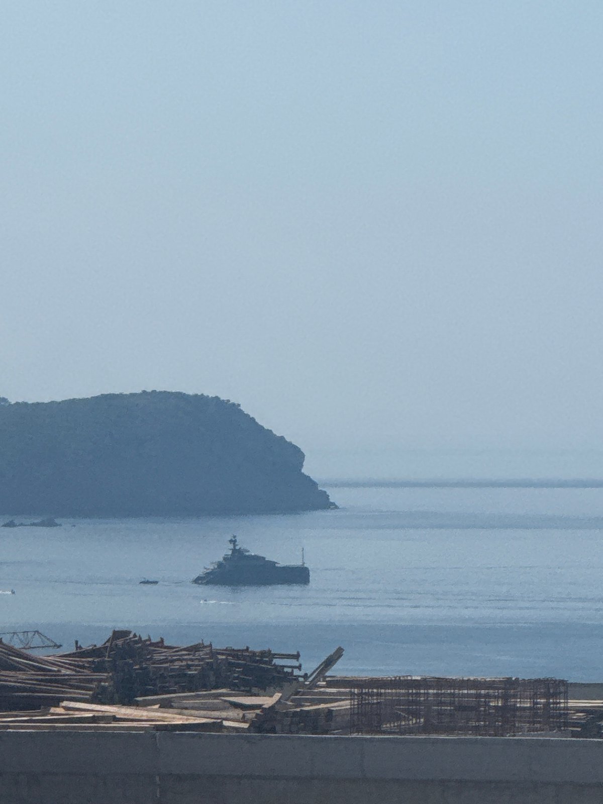 Superyacht anchored off Montenegro coast, viewed from construction site