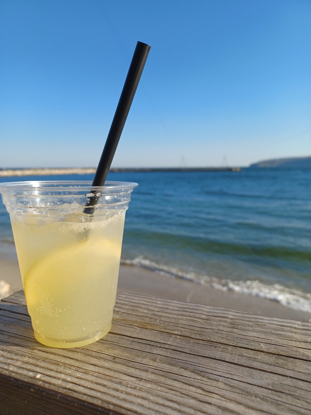 Beverage in plastic cup spotted on wooden surface