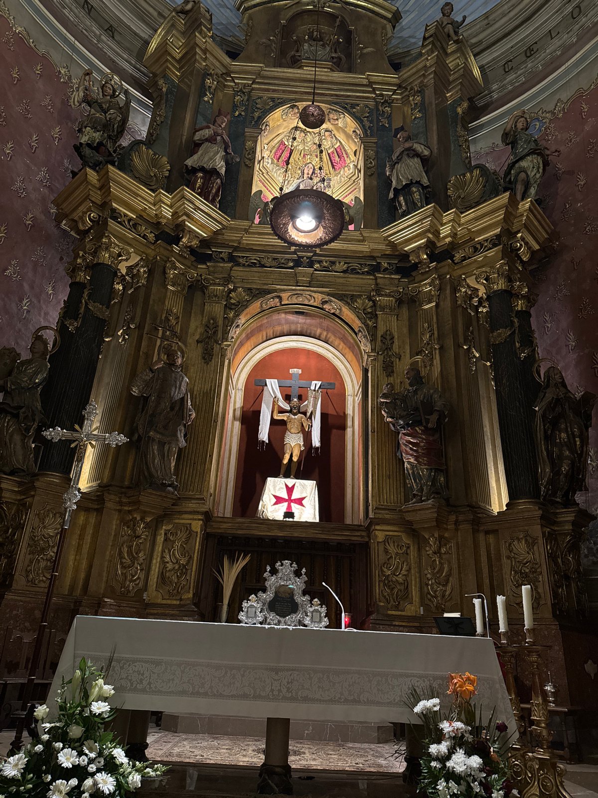 Tourist documents historic church architecture and wet streets in Pollença