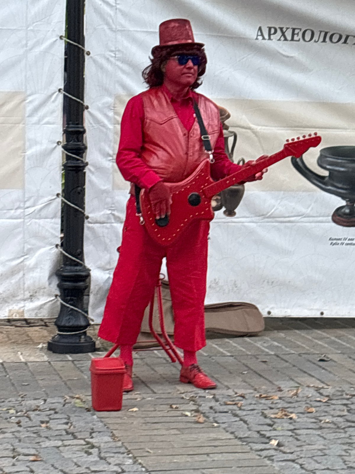 Red rocker, gold statue, and chef figure on cobblestone