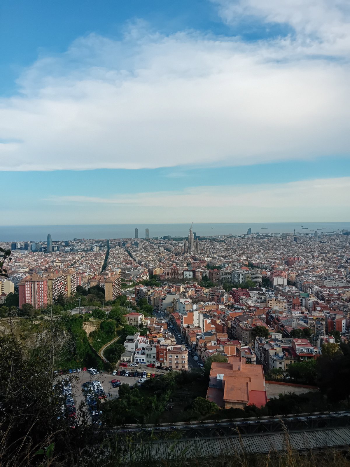 Panoramic view captures Barcelona cityscape extending to Mediterranean Sea