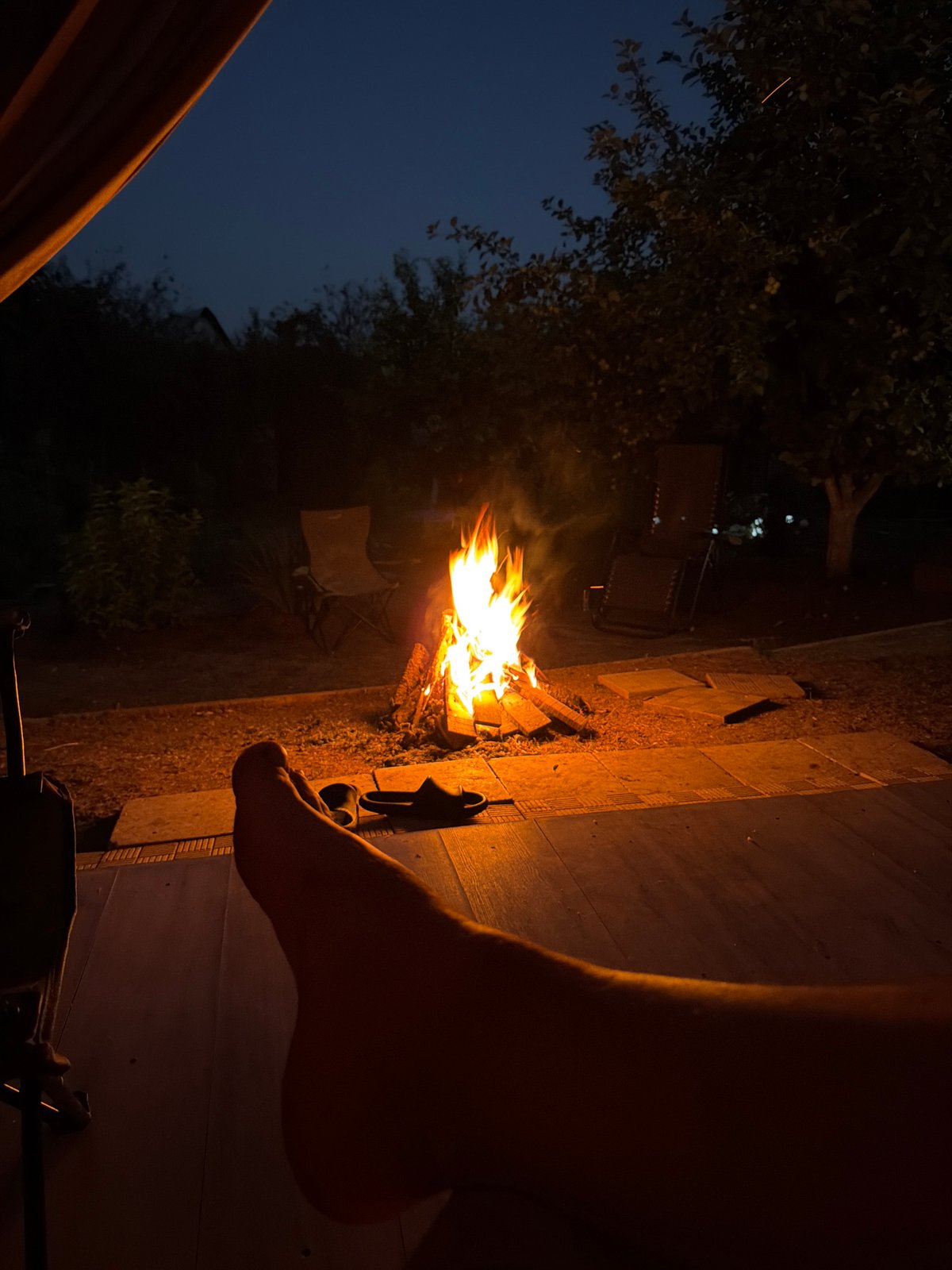 Backyard bonfire glowing at dusk in rural Russia