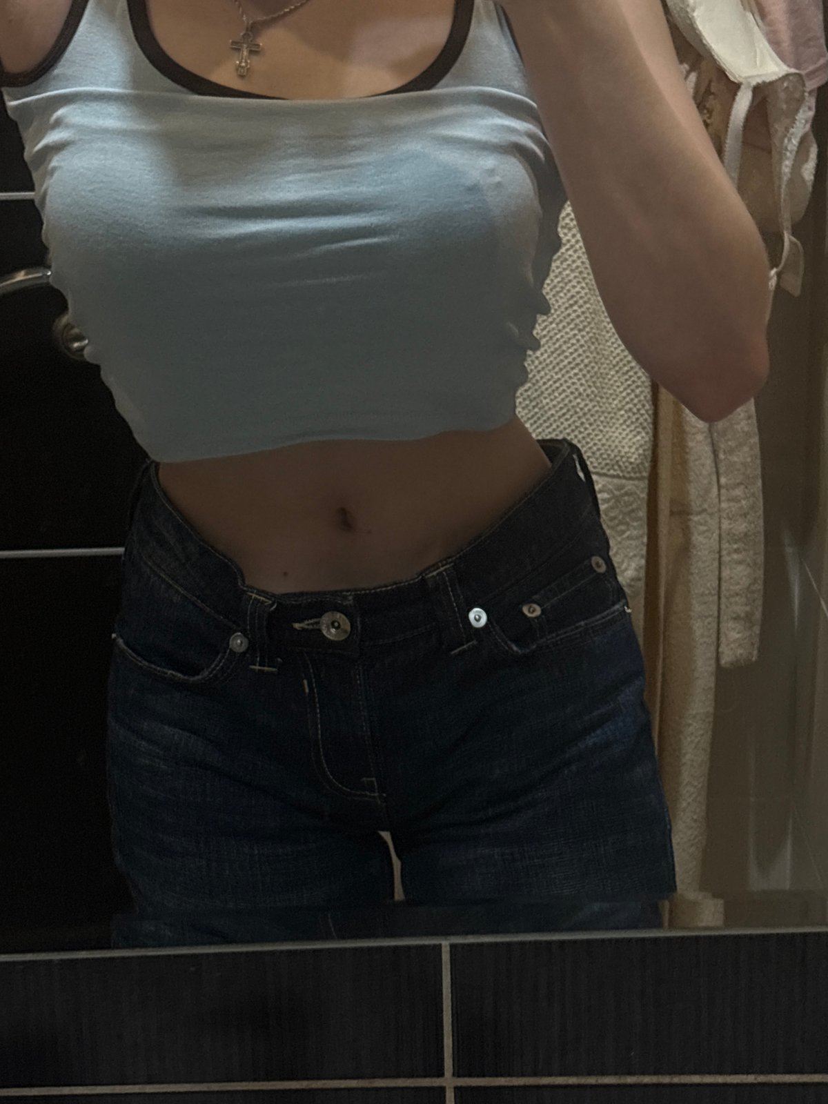 Mirror outfit checks: light blue top, dark denim, silver cross