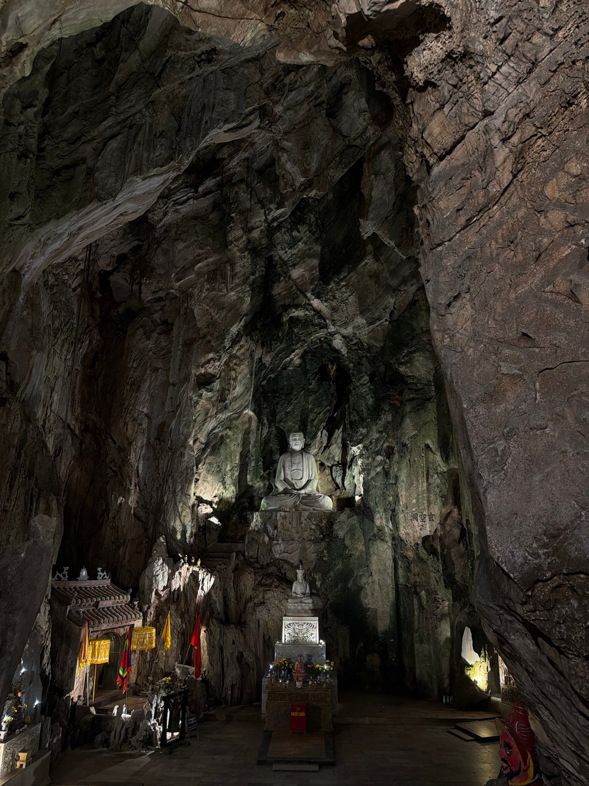 Cave temple with illuminated Buddha statue documented in Đà Nẵng