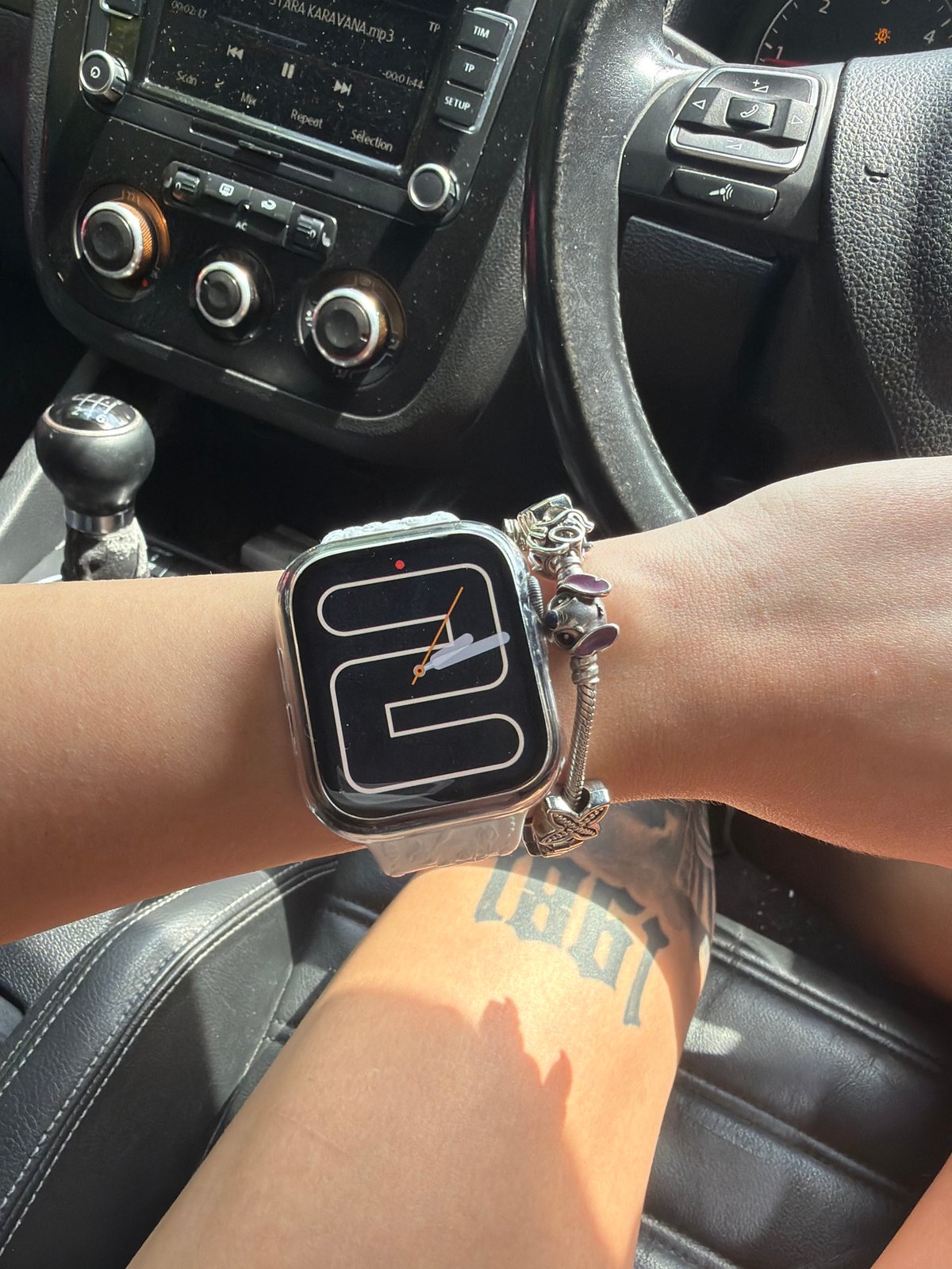 Smartwatch and charm bracelet stacked on a wrist in Plovdiv