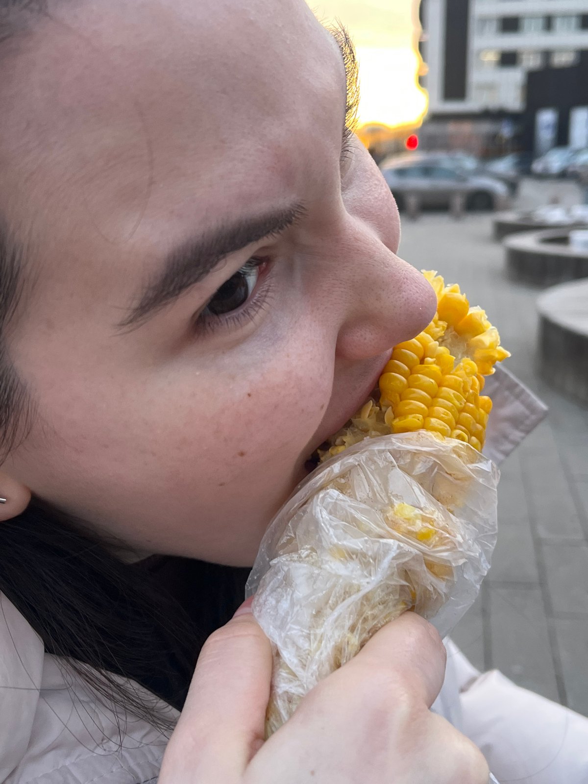 Person eats wrapped corn on cob in Krasnoyarsk