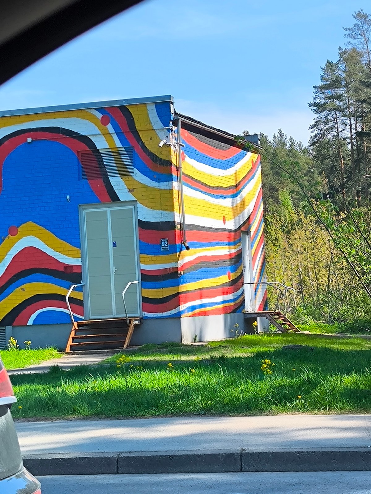 Colorful striped mural spotted on utility building in Riga