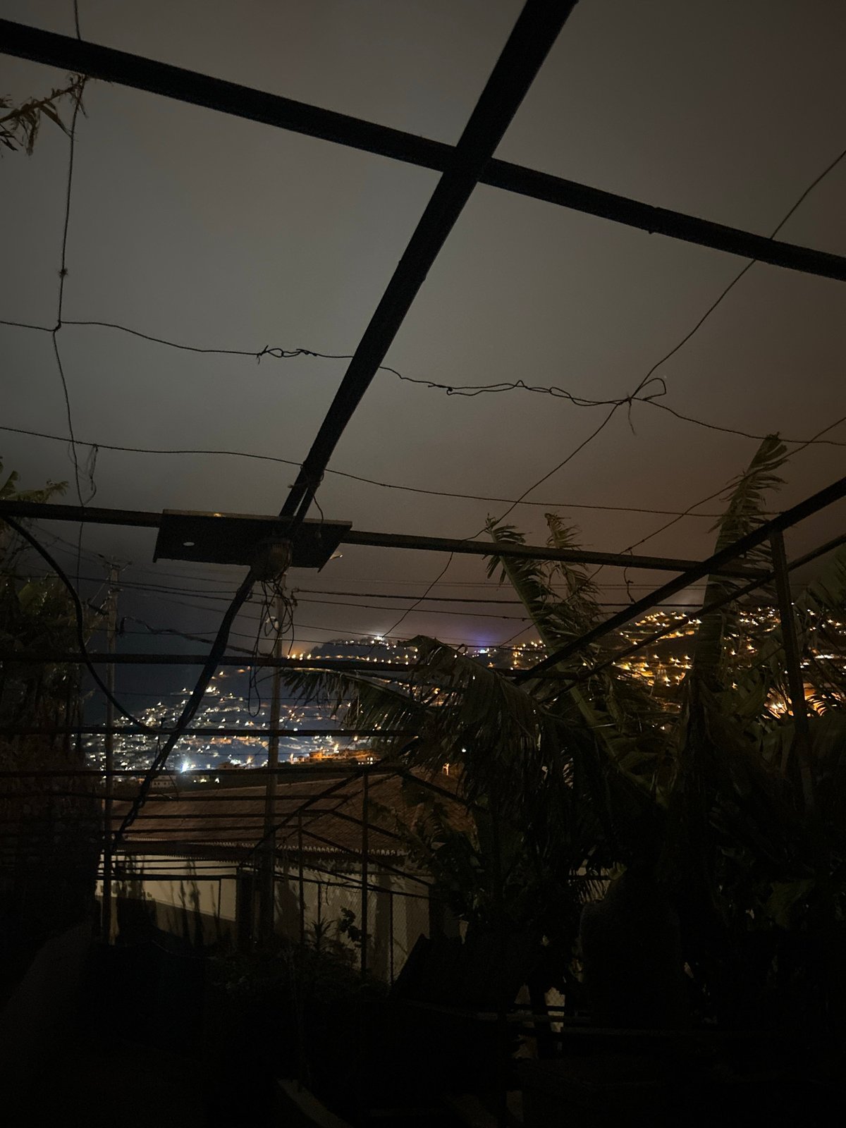 Foggy night captured through metal framework in Câmara de Lobos