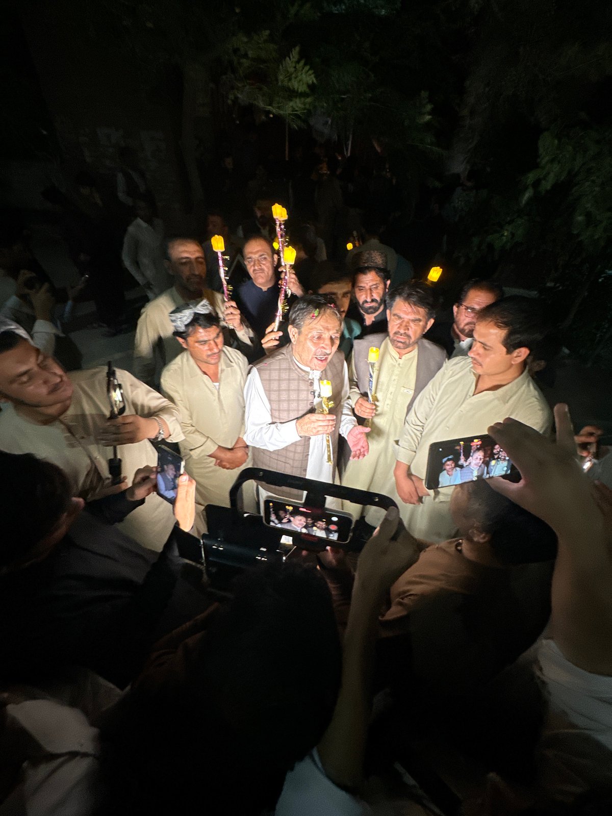 Candlelight vigil with portrait display in Quetta at night