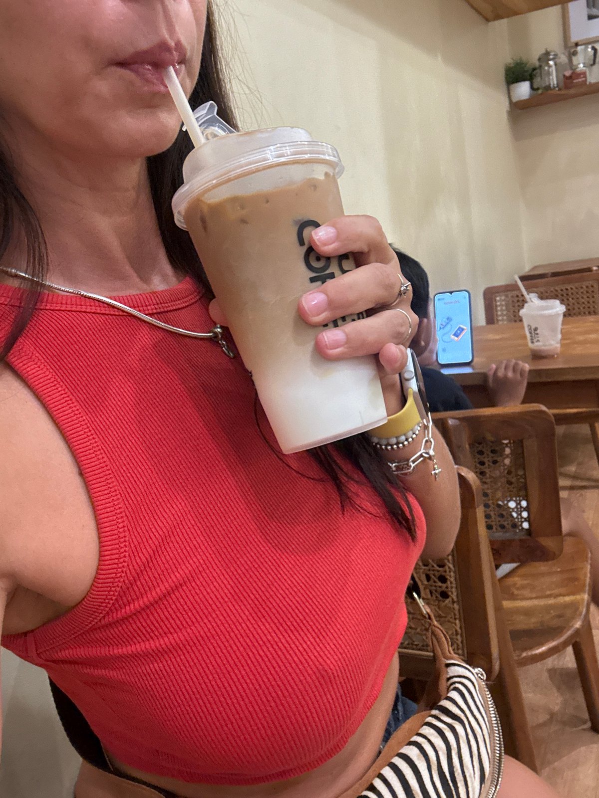 Coffee shop patron enjoys beverage in Kuta Selatan cafe