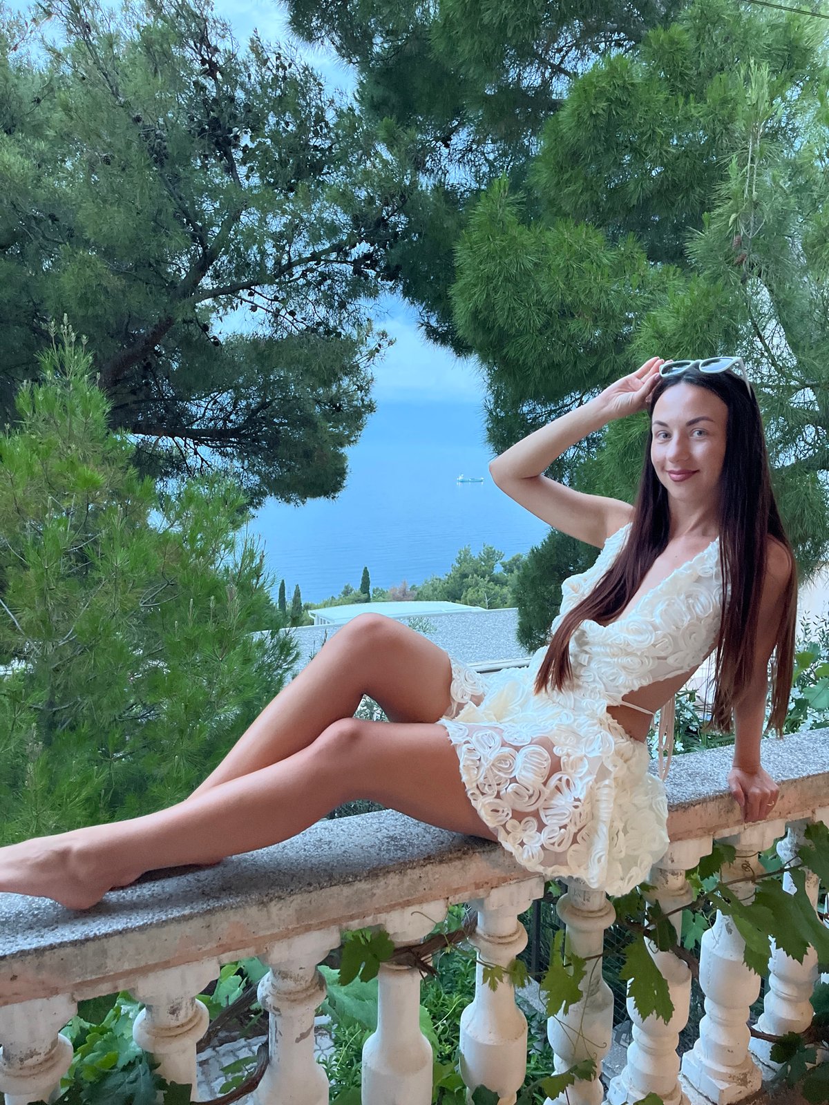 Woman poses for photos on seaside balcony in Montenegro
