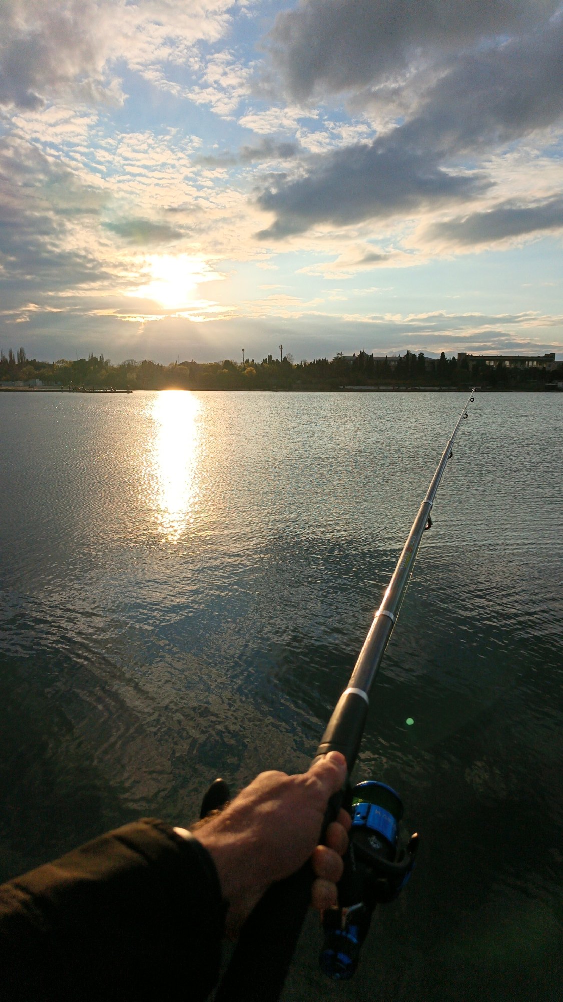 Angler fishes at sunset from Sevastopol waterfront