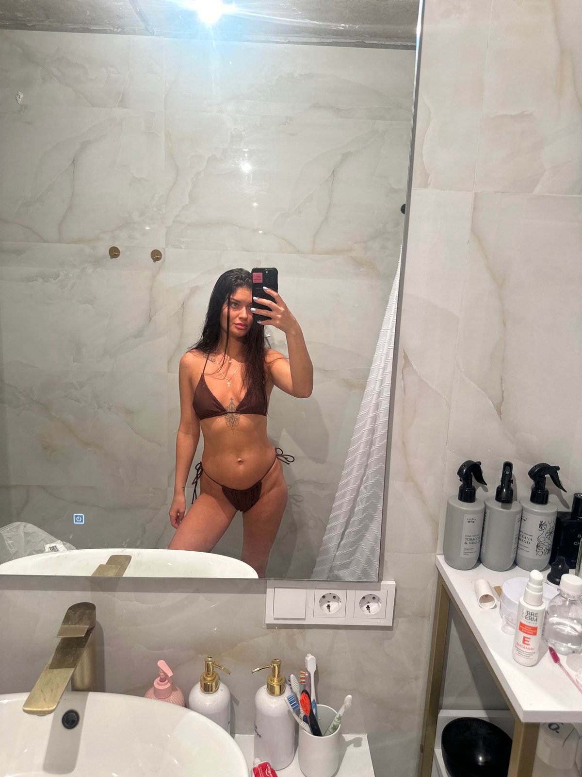 Woman takes mirror selfie in Moscow bathroom
