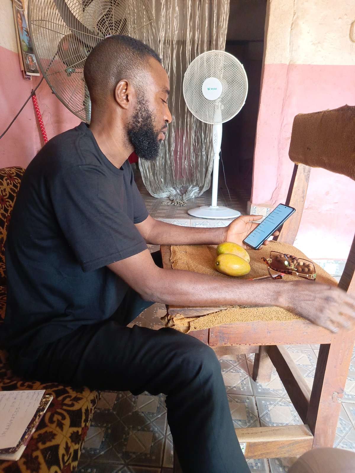 Man with smartphone observed in room with mangoes