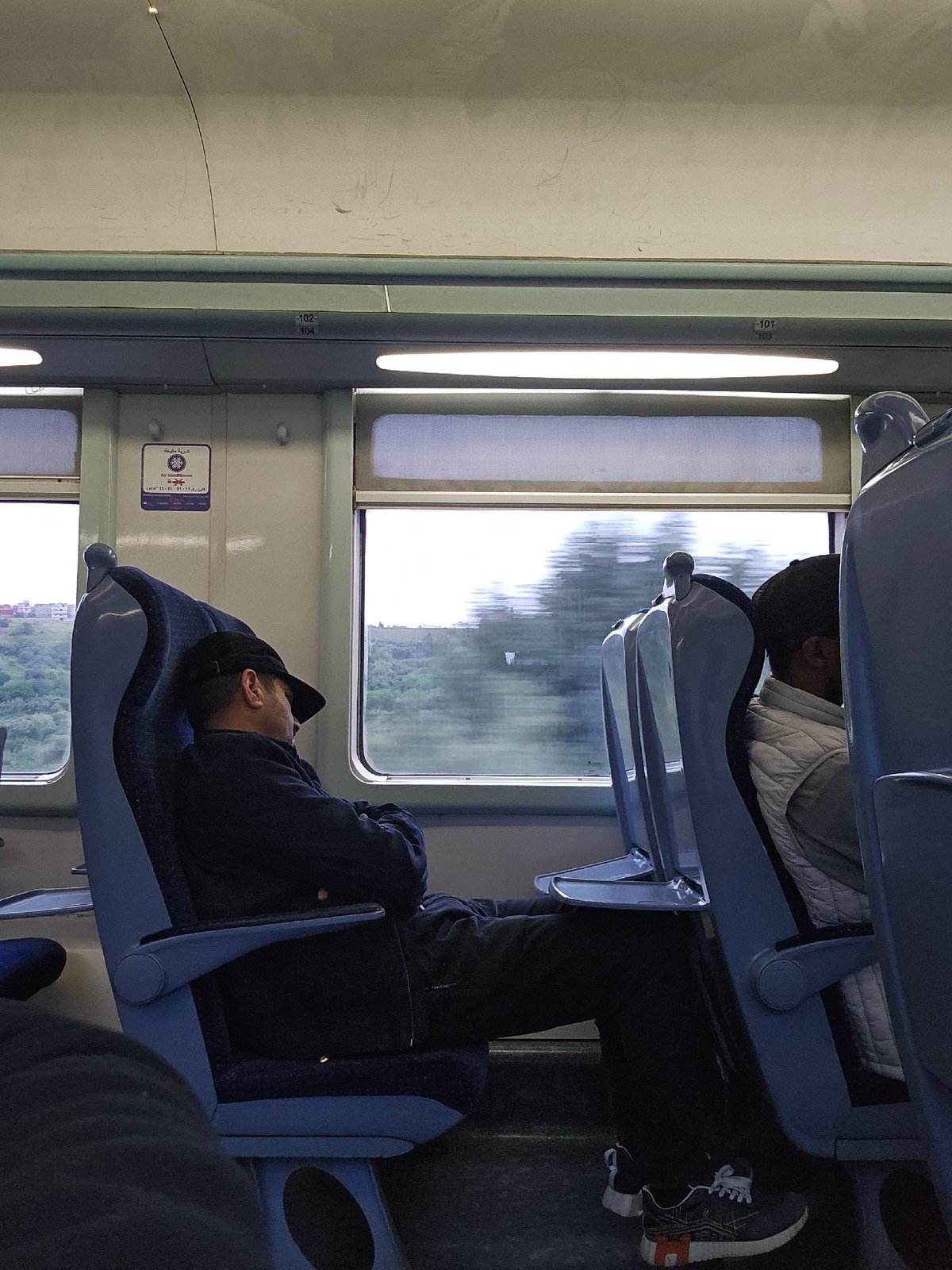 Two passengers travel by train in Dkhissa, Morocco