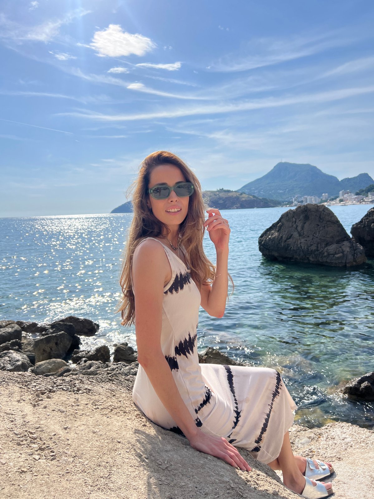Woman relaxes on coastal rocks in Sutomore, Montenegro