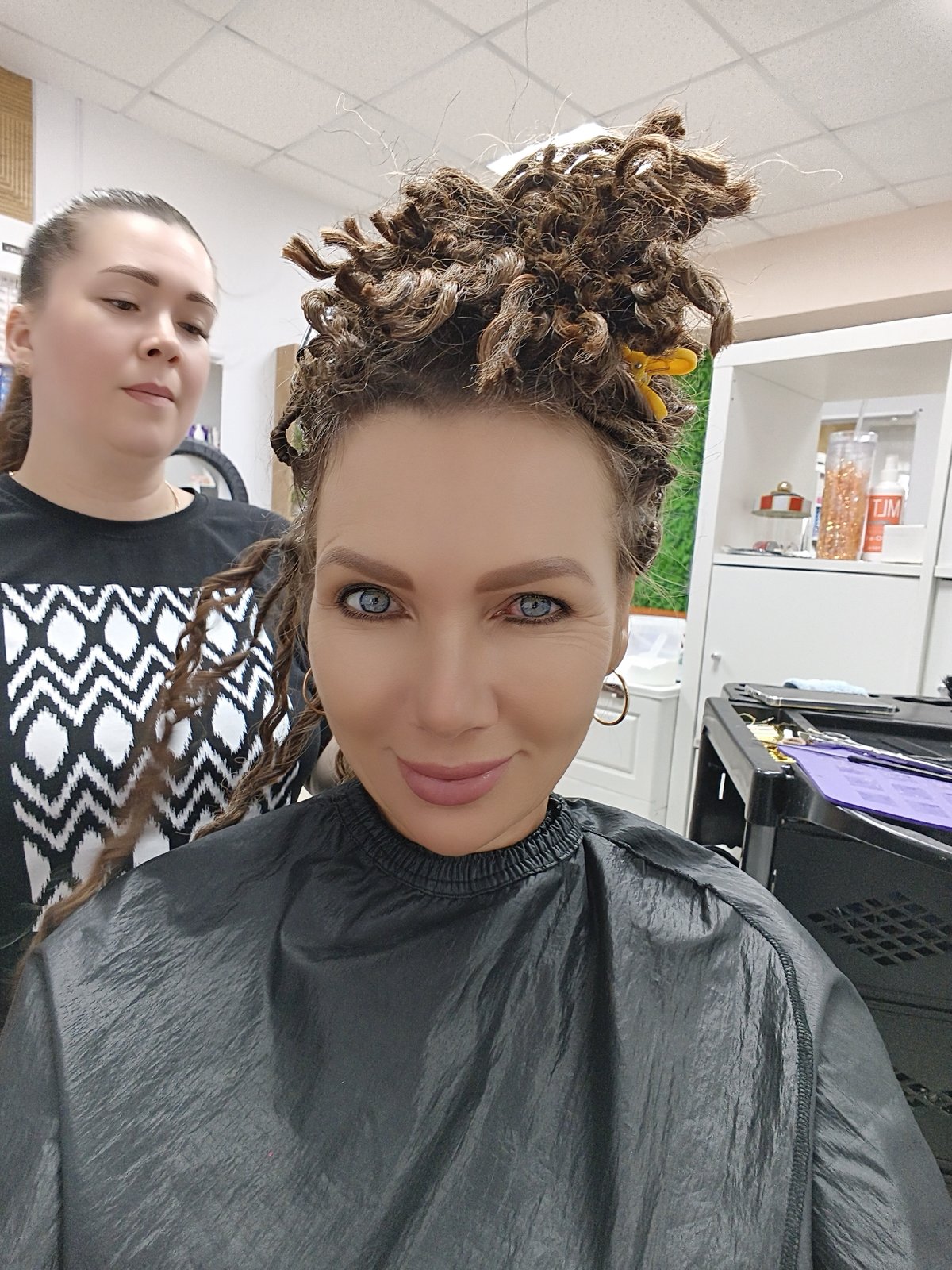 Dreadlock styling session at a Chaikovsky salon, baby in tow