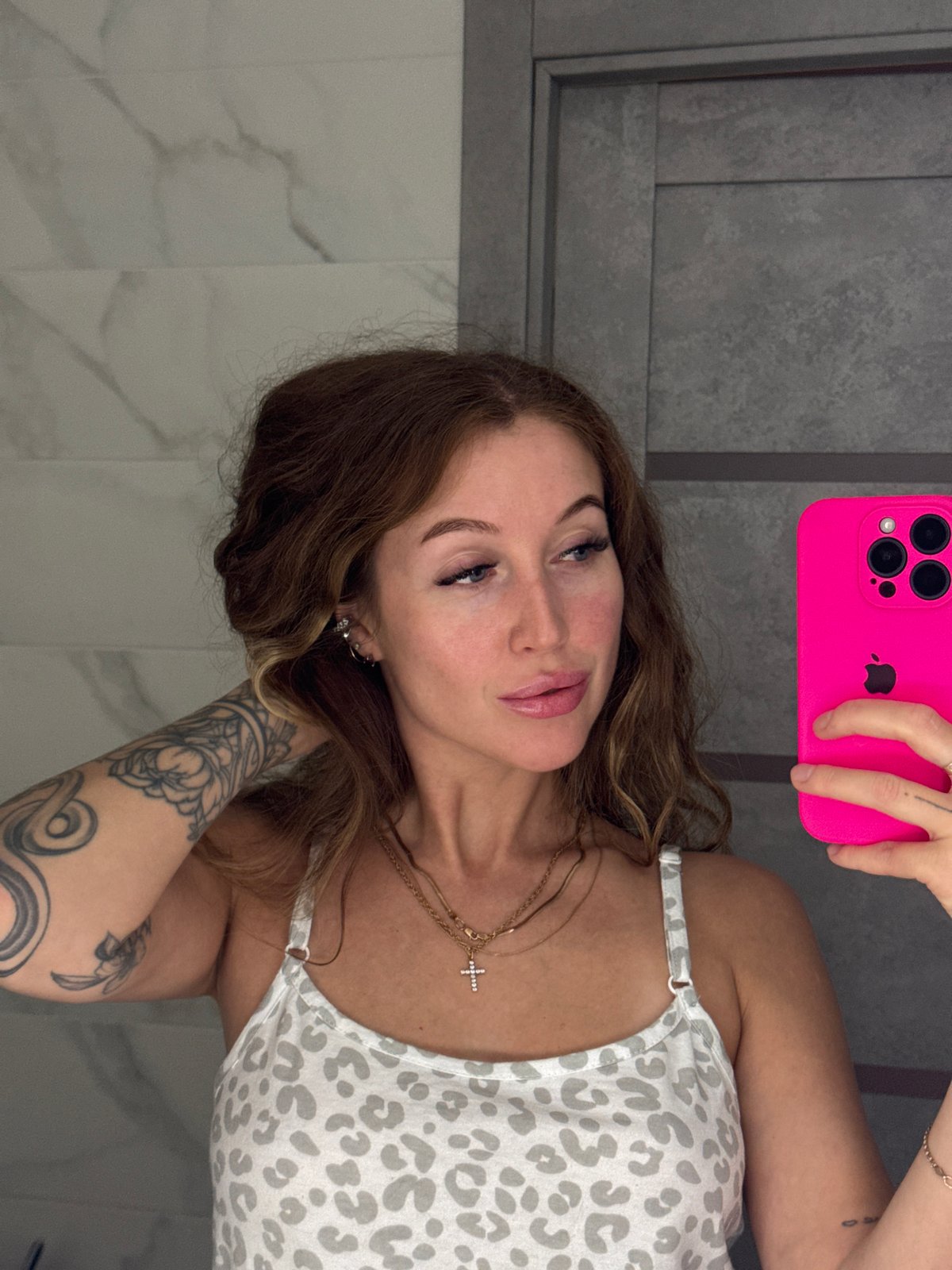 Woman takes bathroom selfie with pink iPhone in Chaikovsky