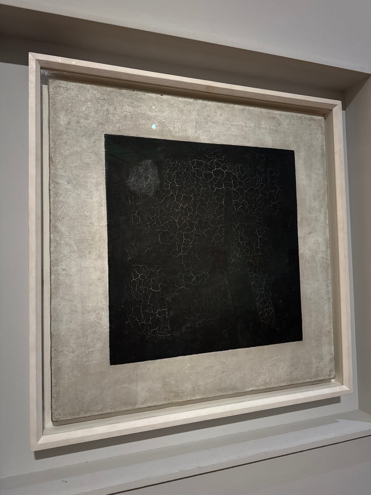 Gallery visitors document diverse artworks including Malevich's Black Square