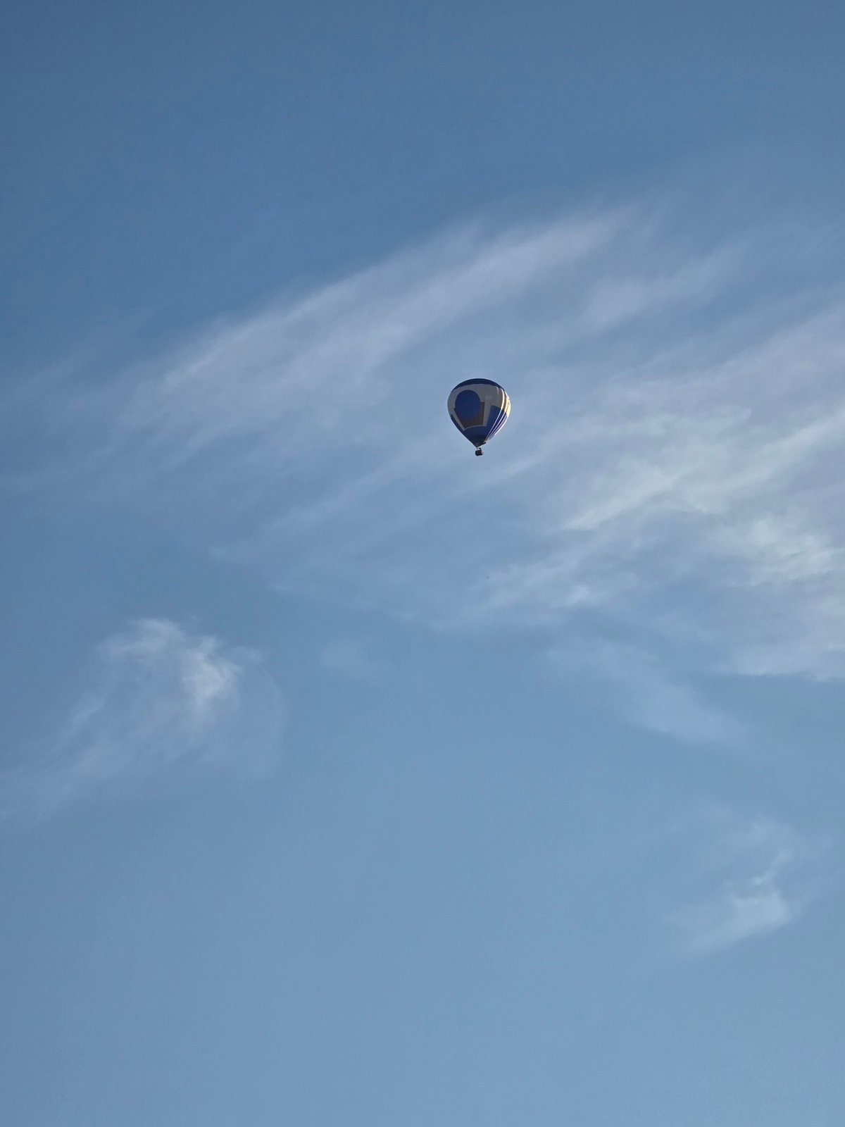 Hot air balloon drifts over Ghent on a clear evening