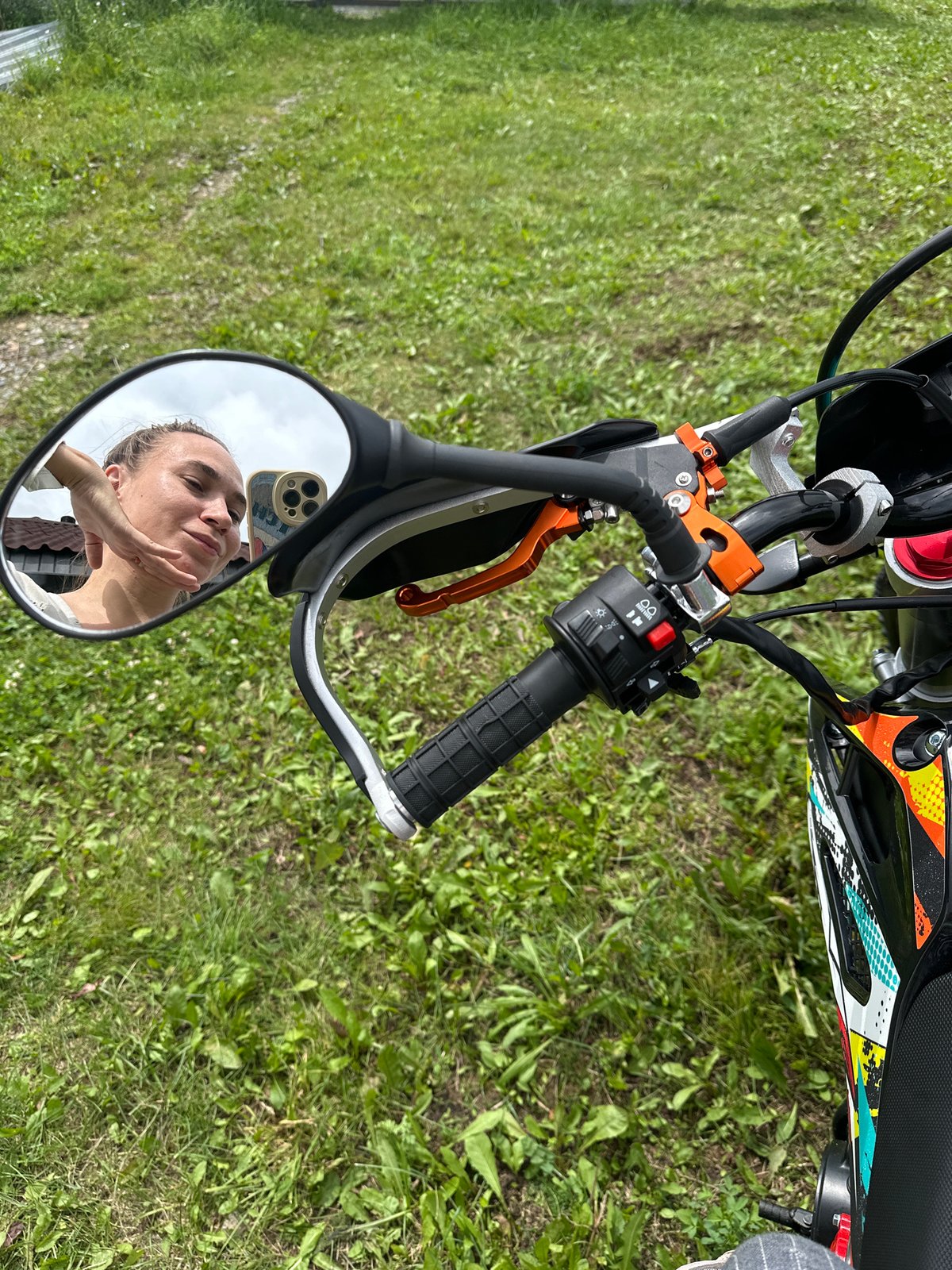 Hanging around a dirt bike on a grassy day in Kharnavy